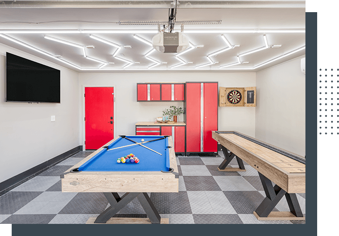 A room with a pool table and red cabinets.