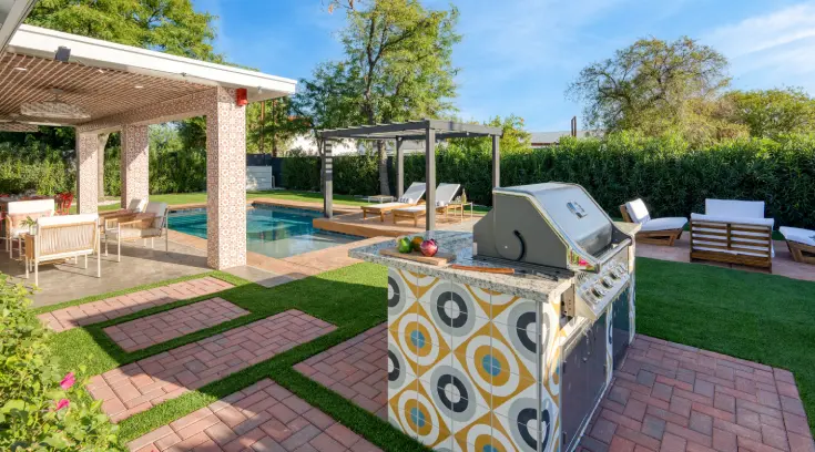 A grill and an outdoor pool in the background.