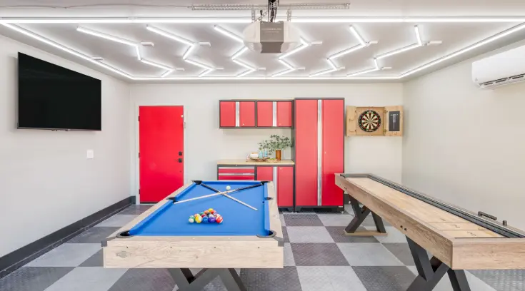 A pool table in the center of a room with red walls.