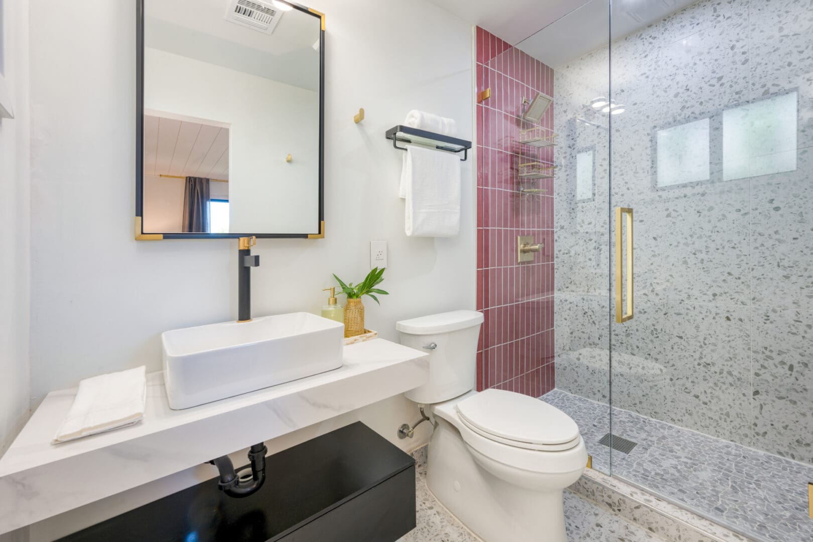 A bathroom with a toilet, sink and shower.