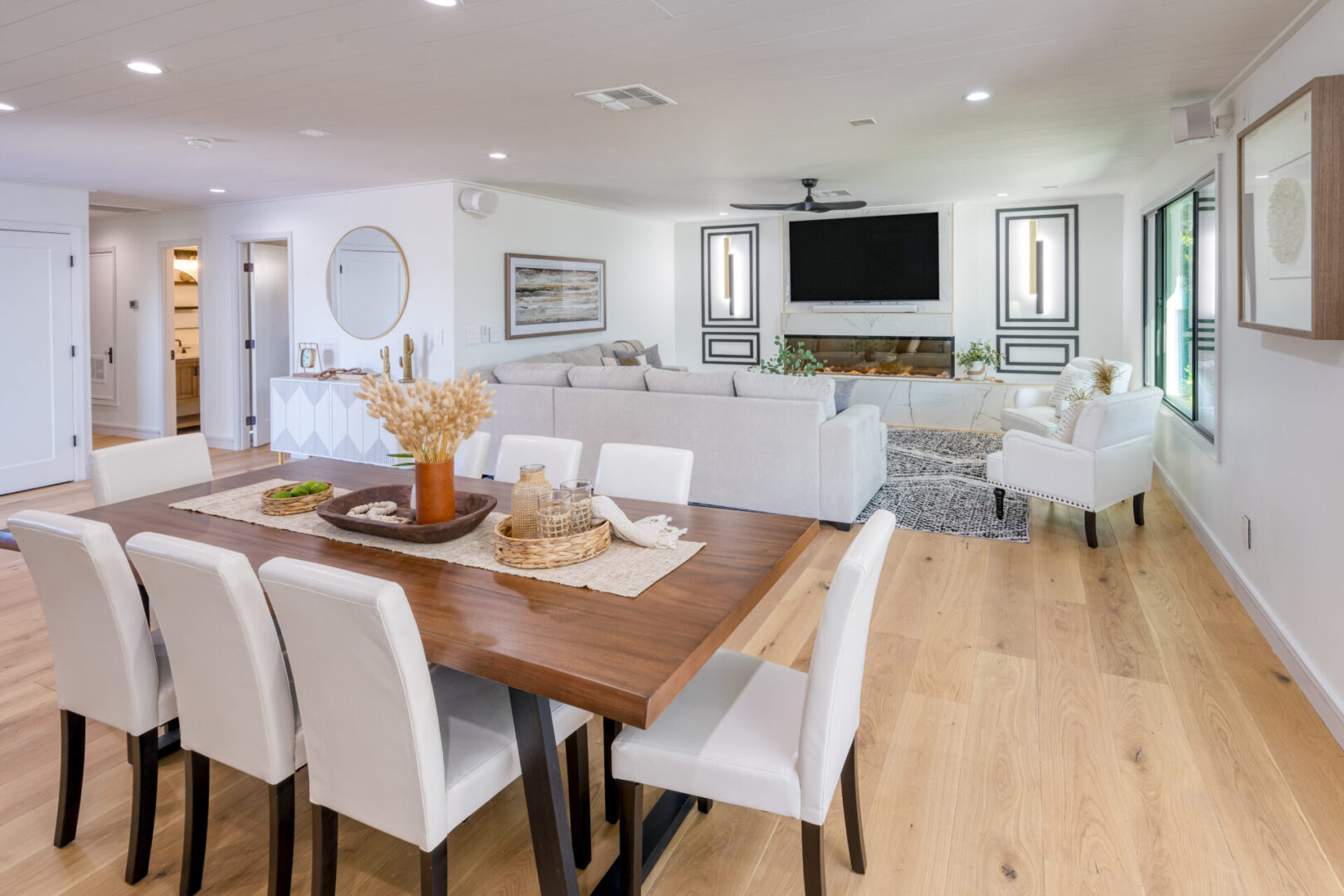 A large dining room table with white chairs.