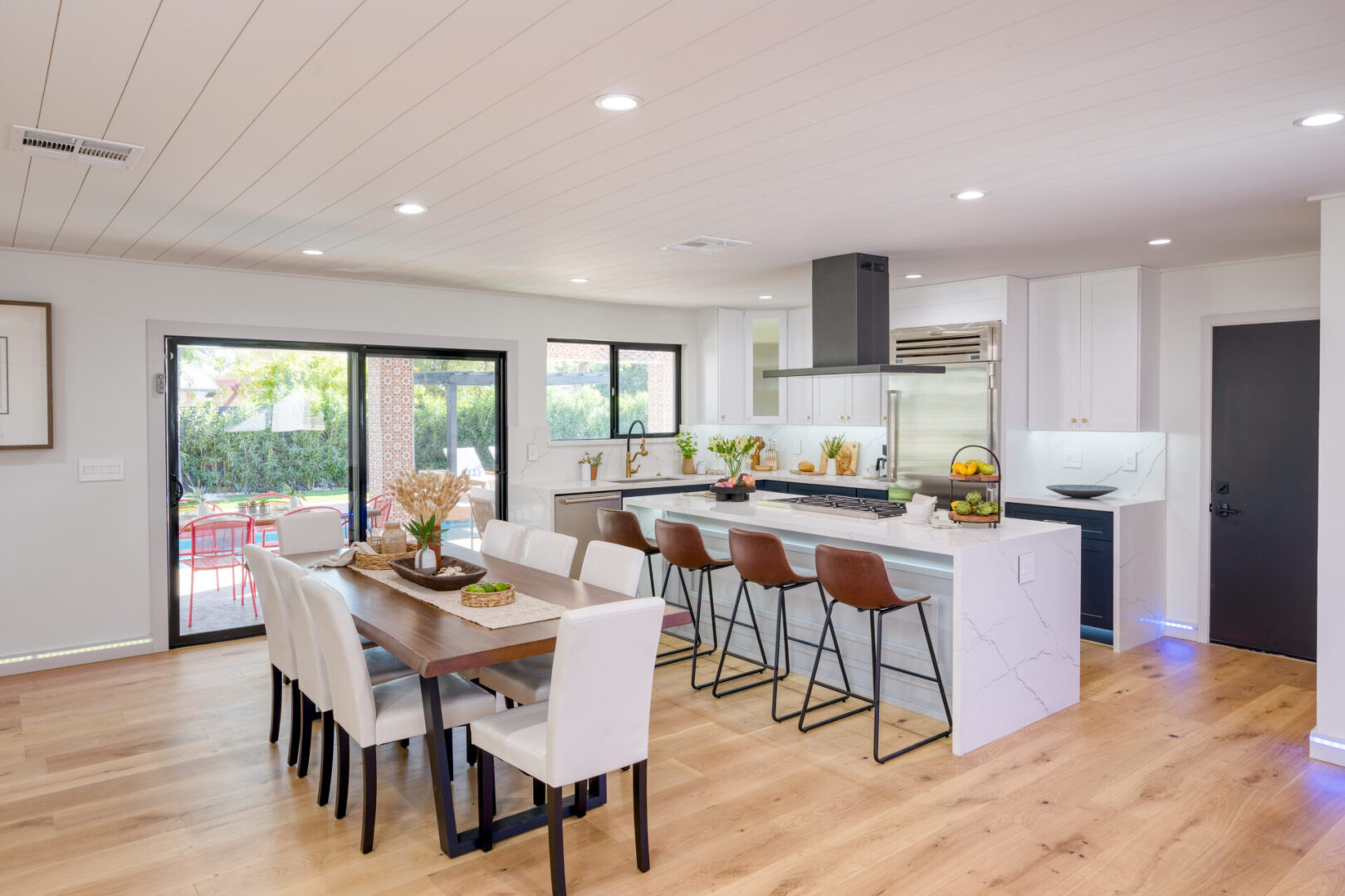 A large open kitchen with white cabinets and wood floors.