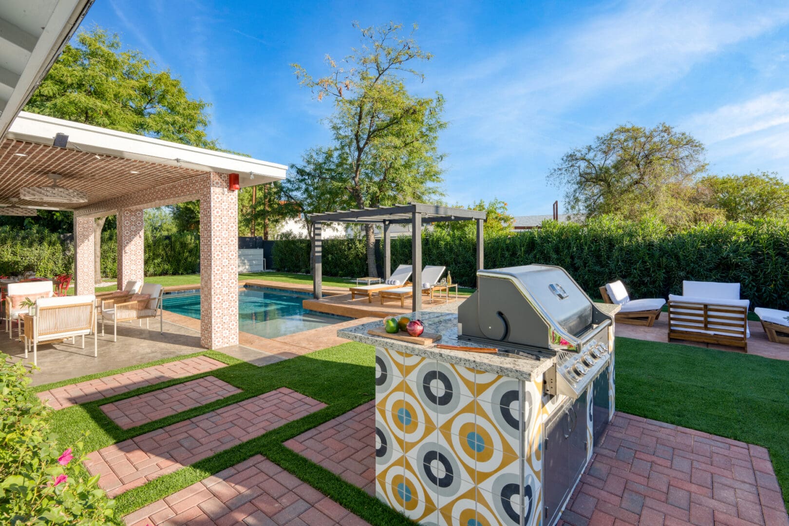 A backyard with an outdoor grill and pool.