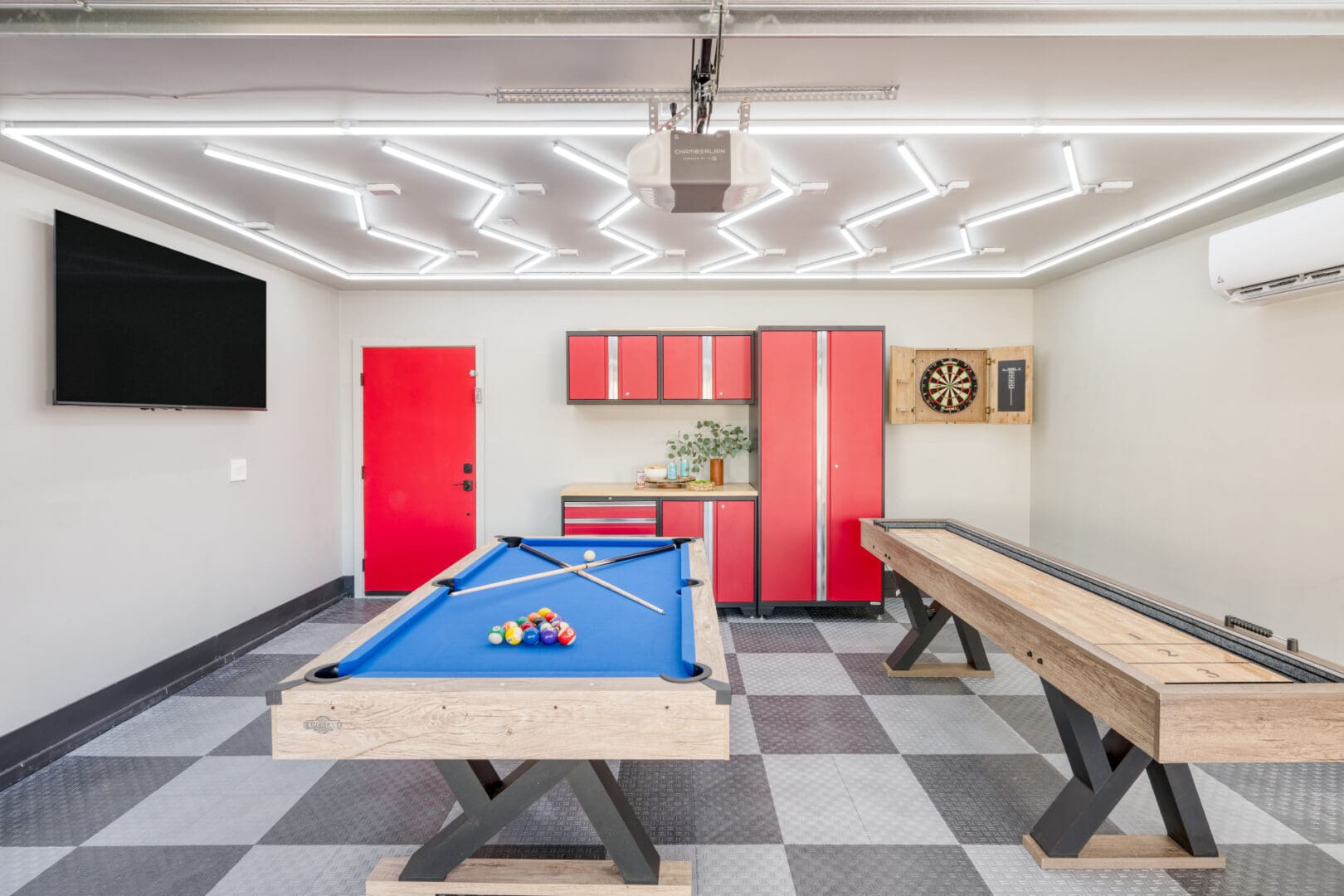 A room with a pool table and two benches.