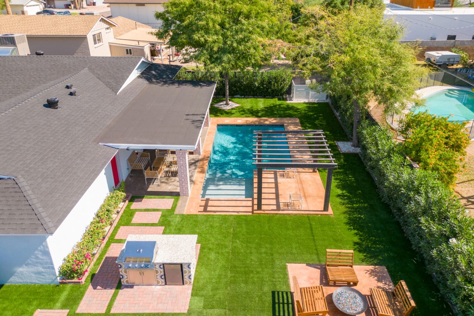 A backyard with an outdoor pool and patio furniture.