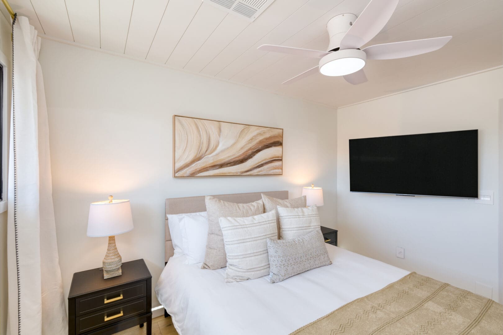 A bedroom with a bed, nightstand and television.